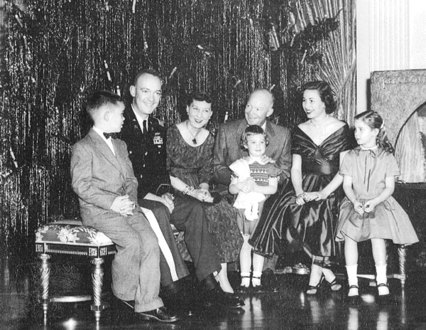 President Dwight D. Eisenhower and family, Christmas 1955. From left to right, David Eisenhower, General John S.D. Eisenhower, First Lady Mamie Eisenhower, Susan Eisenhower, President Dwight Eisenhower, Barbara Thompson Eisenhower Foltz, and Anne Eisenhower (Mary Jean, the youngest sibling, is not pictured)